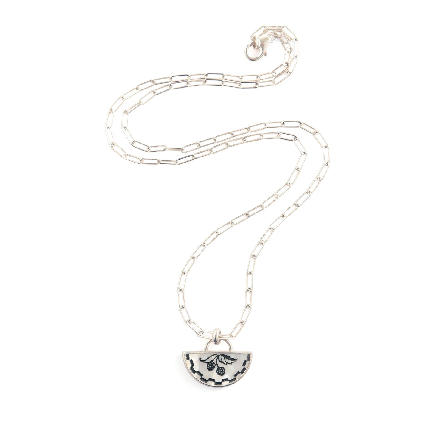 half moon mother of pearl pendant, etched with blackberry design., on silver chain.