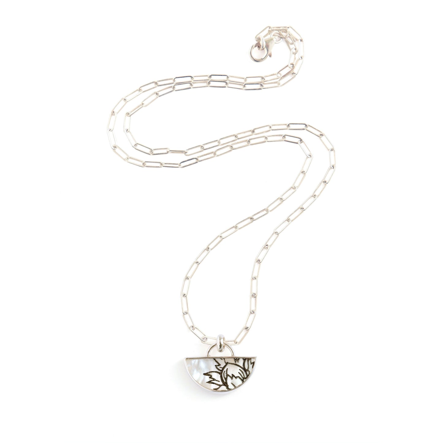 half moon mother of pearl pendant, etched with botanical design., on silver chain.