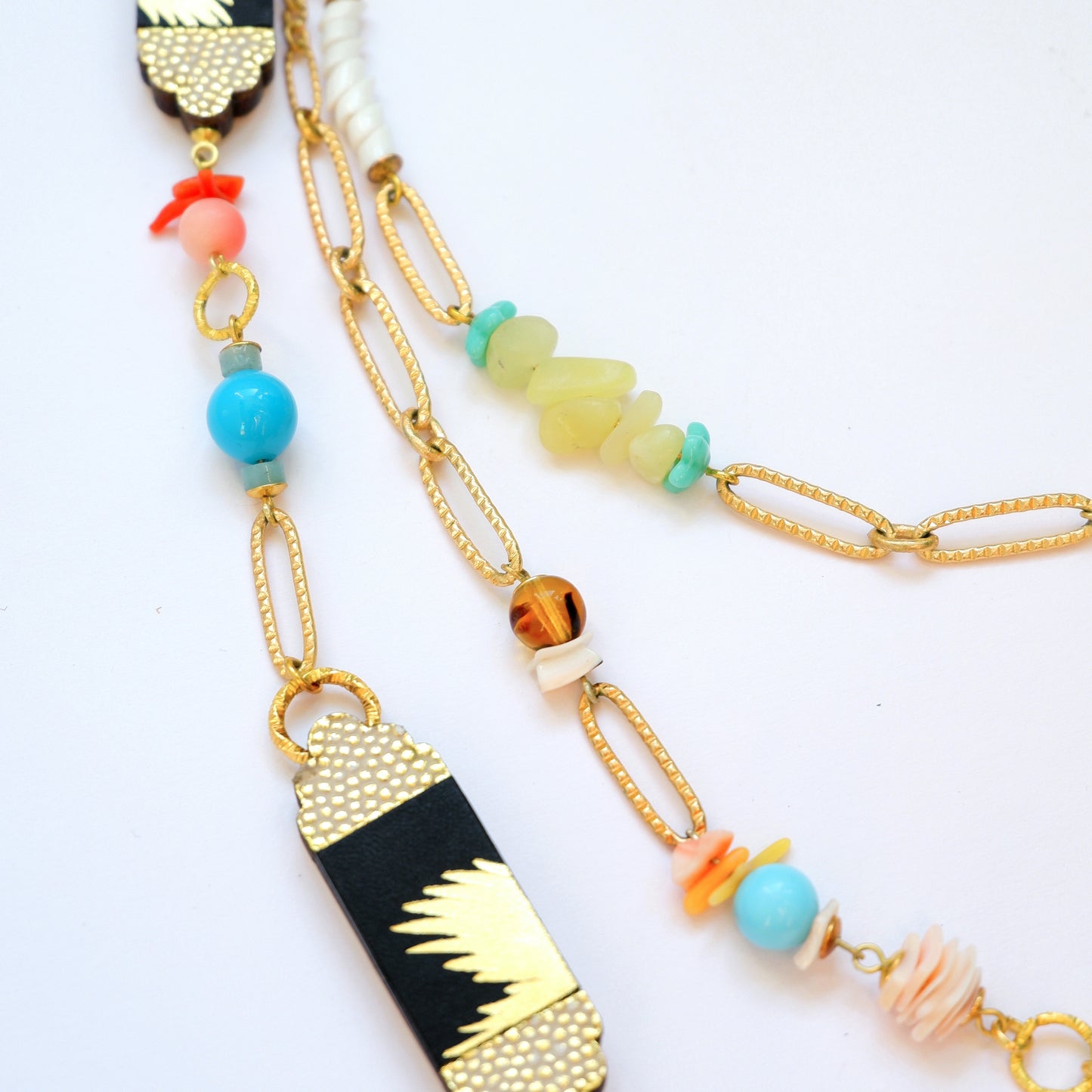 multi strand beaded chain necklace with palm-print black leather pieces close crop