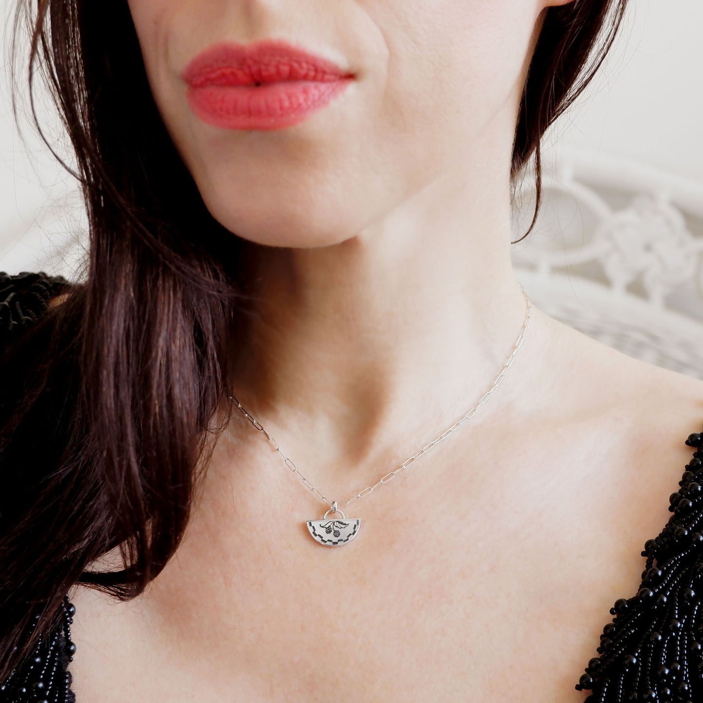 half moon mother of pearl pendant, etched with blackberry design., on silver chain, on model