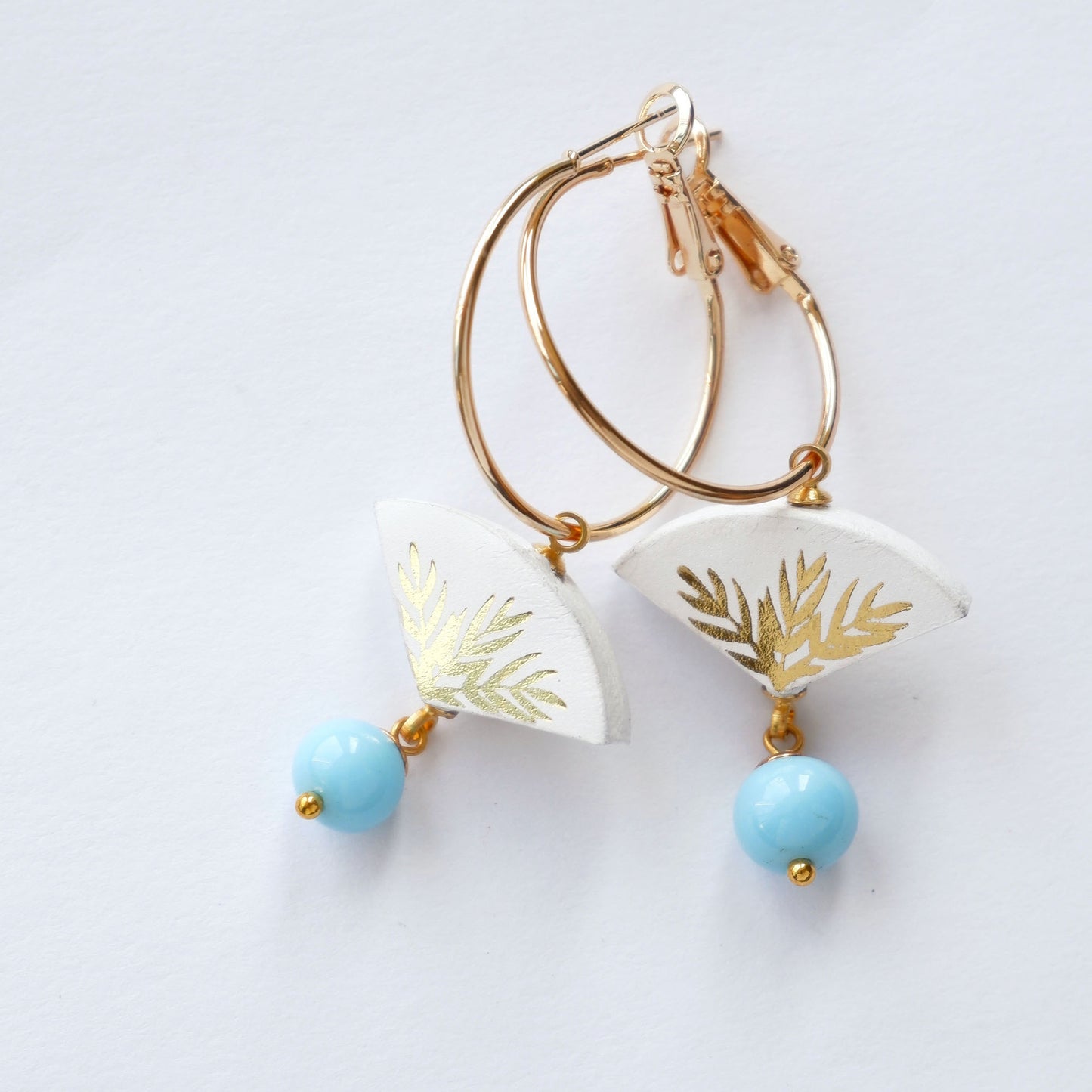 white & gold palm print leather gold hoop earrings with light blue bead