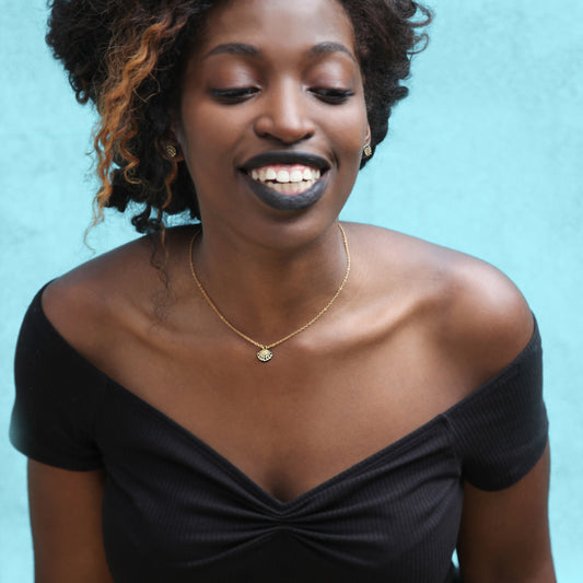 model wearing tiny leather shell pendant & stud earrings