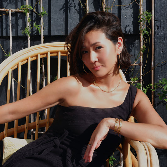 bamboo bar necklace & hoops earrings set, on model on garden on bamboo chair