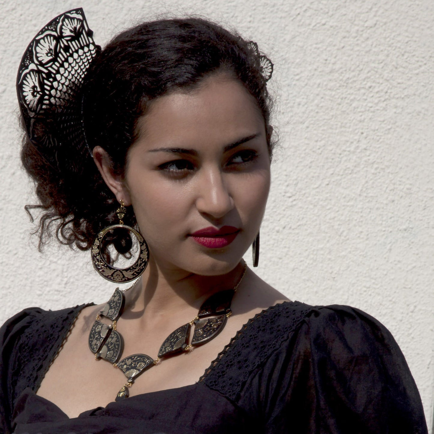 Model weraing large black & gold leather hoops earrings, fan necklace & black cut-out hair comb