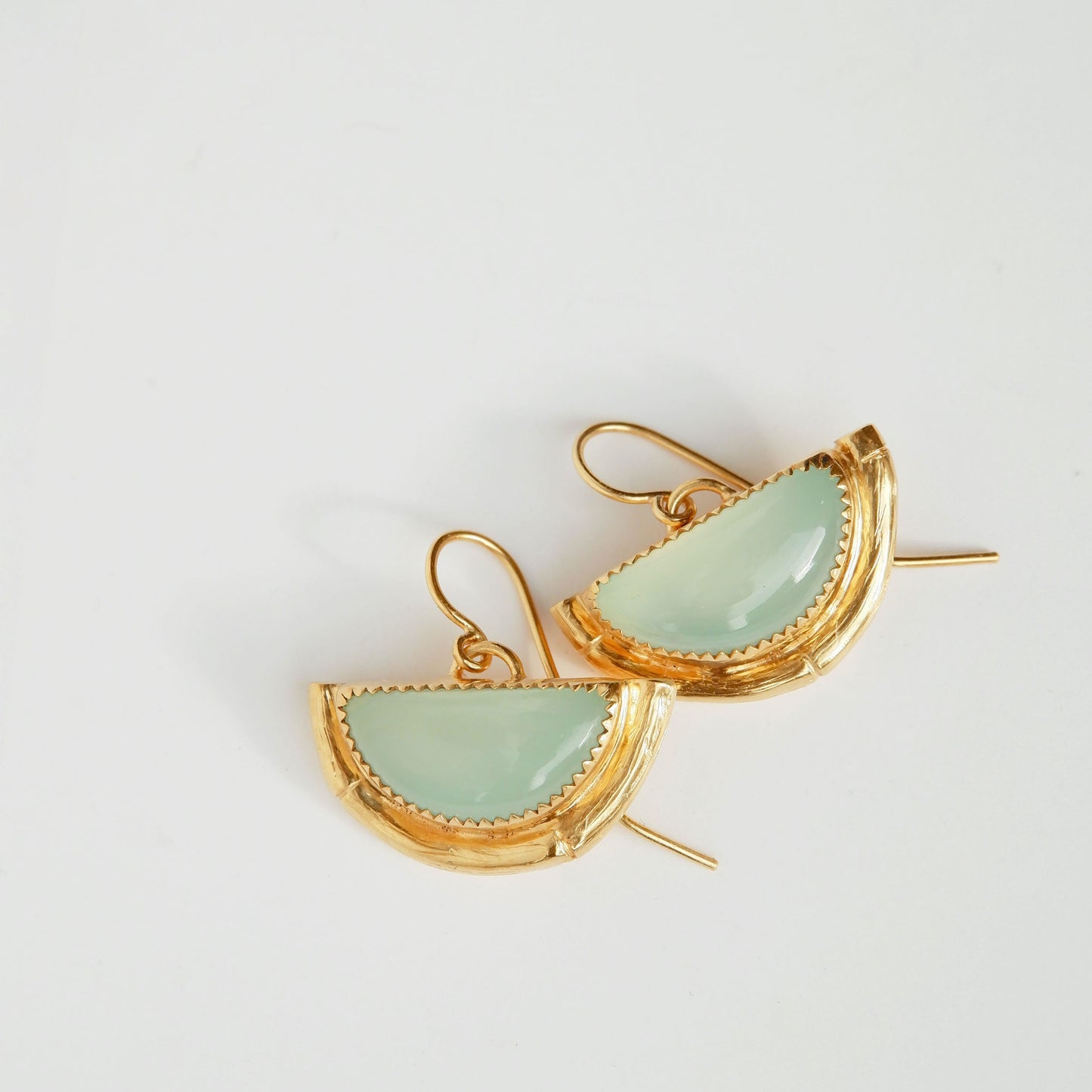 Earrings featuring half moon shaped semi precious aqua blue chalcedony gemstones,  cupped by solid silver bamboo hammock, plated in gold vermeil, with simple wire ear hooks.