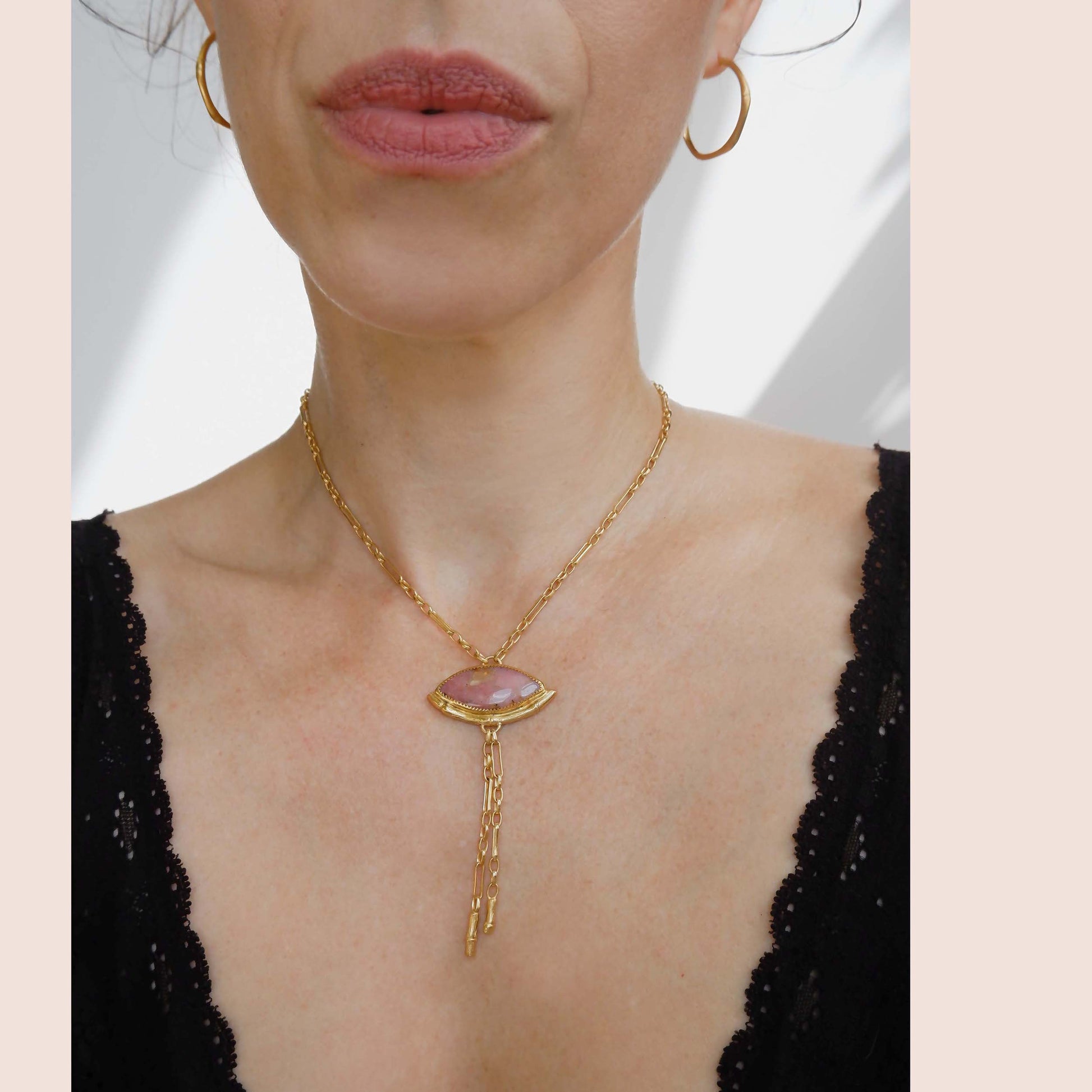 Gold Lariat style chain necklace, with a  wide Marquise shaped Pink Peruvian opal gemstone pendant, framed  by a half halo of Gold bamboo. On model, with Gold Bamboo Hoop earrings.