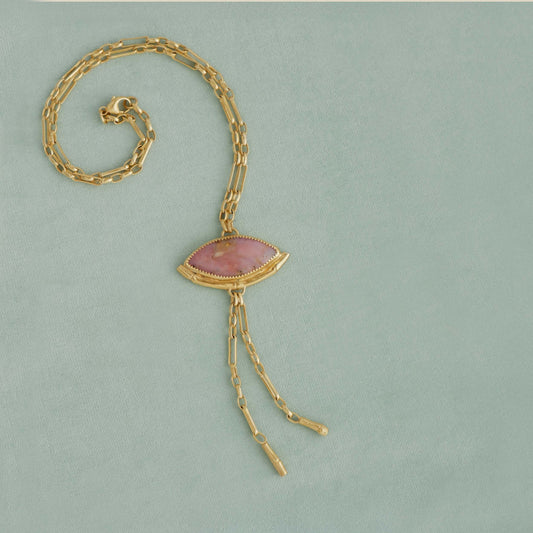 Gold Lariat style chain necklace, with a  wide Marquise shaped Pink Peruvian opal gemstone pendant, framed by a half halo of Gold bamboo. On light duck egg velvet background.