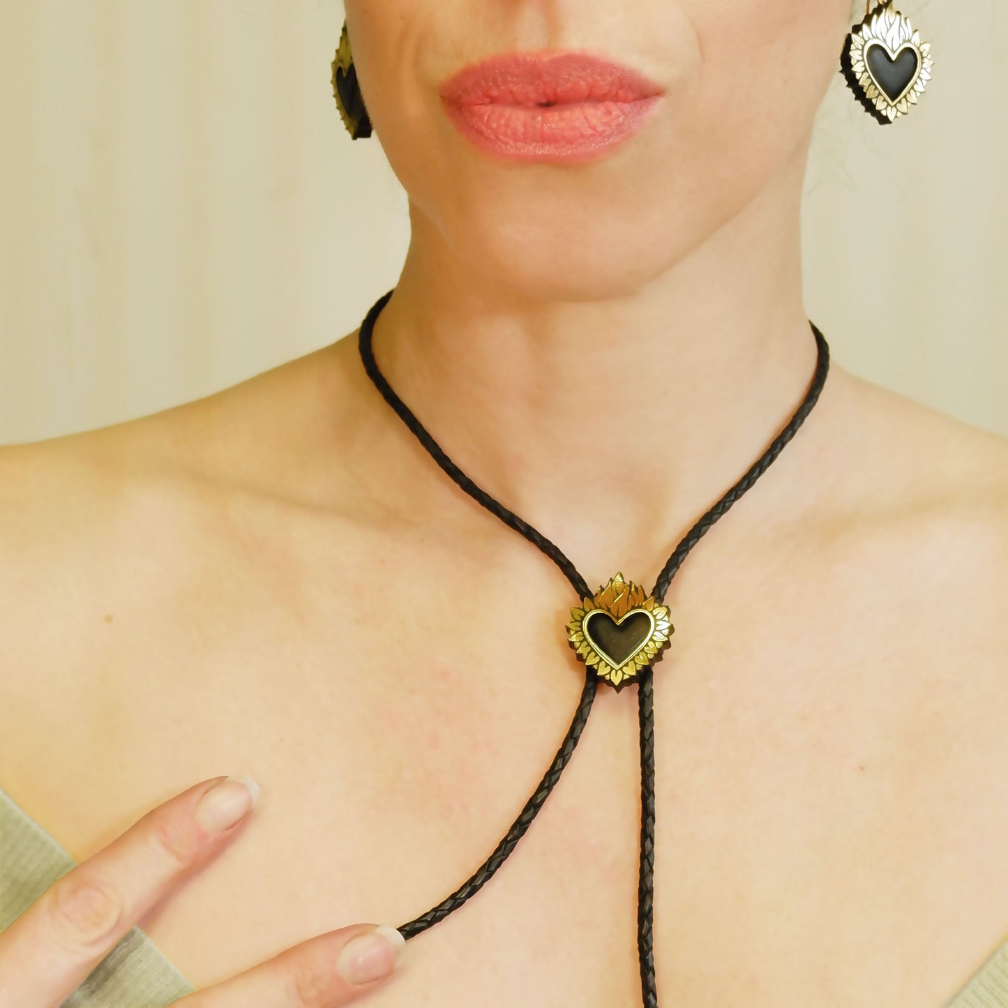 Flaming Heart Pendant, in Gold Foiled Leather, with a black padded leather centre, mounted on black braided leather bolo cord. Shown on model, with matching earrings