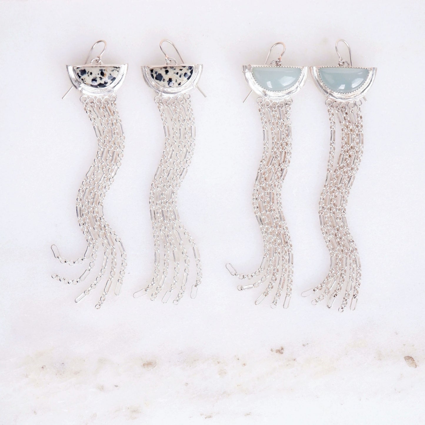 two pairs of sterling silver  tassel earrings with half moon shaped semi precious aqua blue chalcedony  and speckled dalmatian jasper gemstones,  cupped by solid silver bamboo hammock, with simple silver wire hooks.