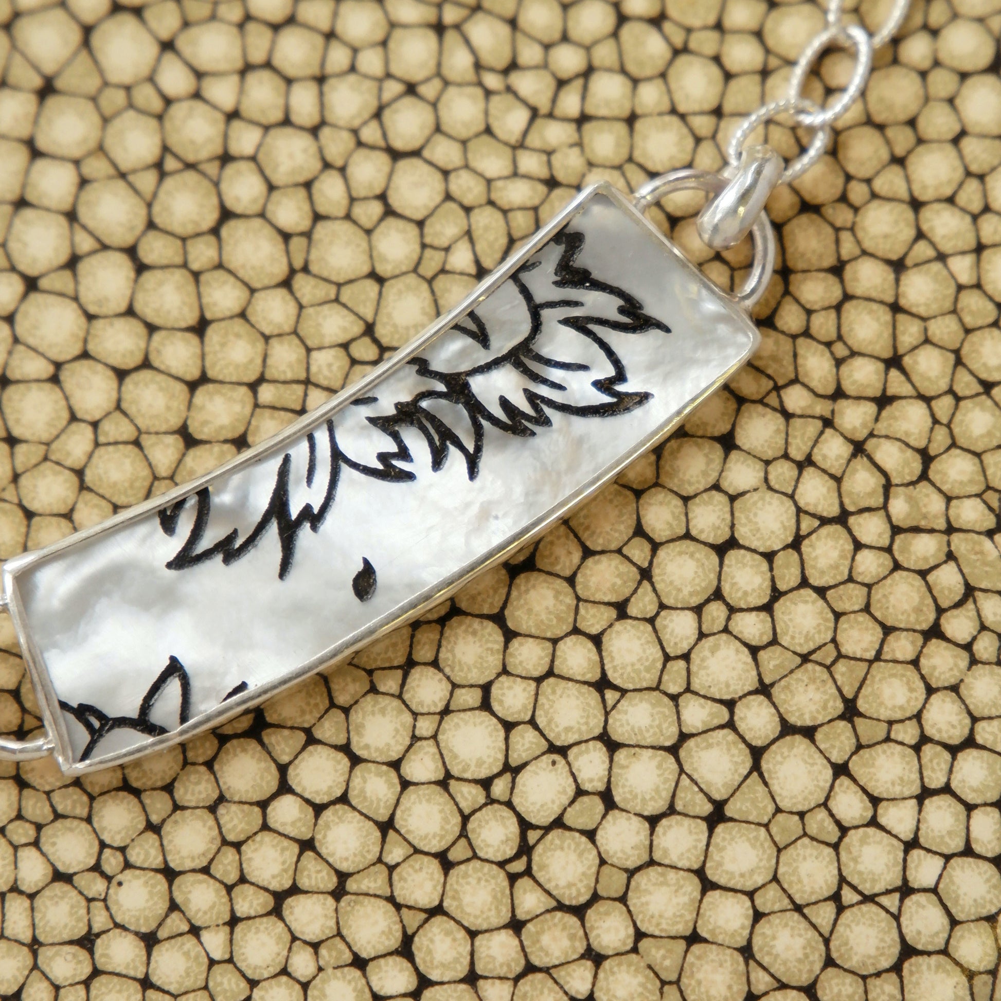 close-up shot - mother of pearl collar necklace, with botanical pattern, in sterling silver