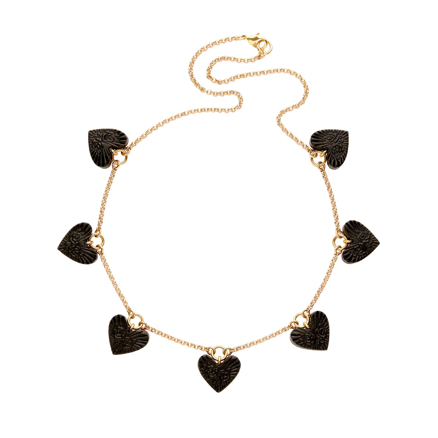 Charm necklace, featuring 7 small  Black Leather Heart pendant; embossed with a  rose & rays design, on fine gold-plated belcher chain.