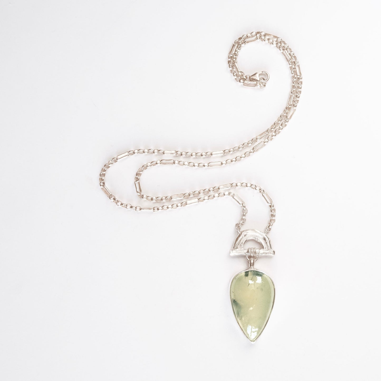 Pendant with  Pear-shaped pale green Prehnite Gemstone hanging from silver Bamboo Arch, on fine silver chain. white background