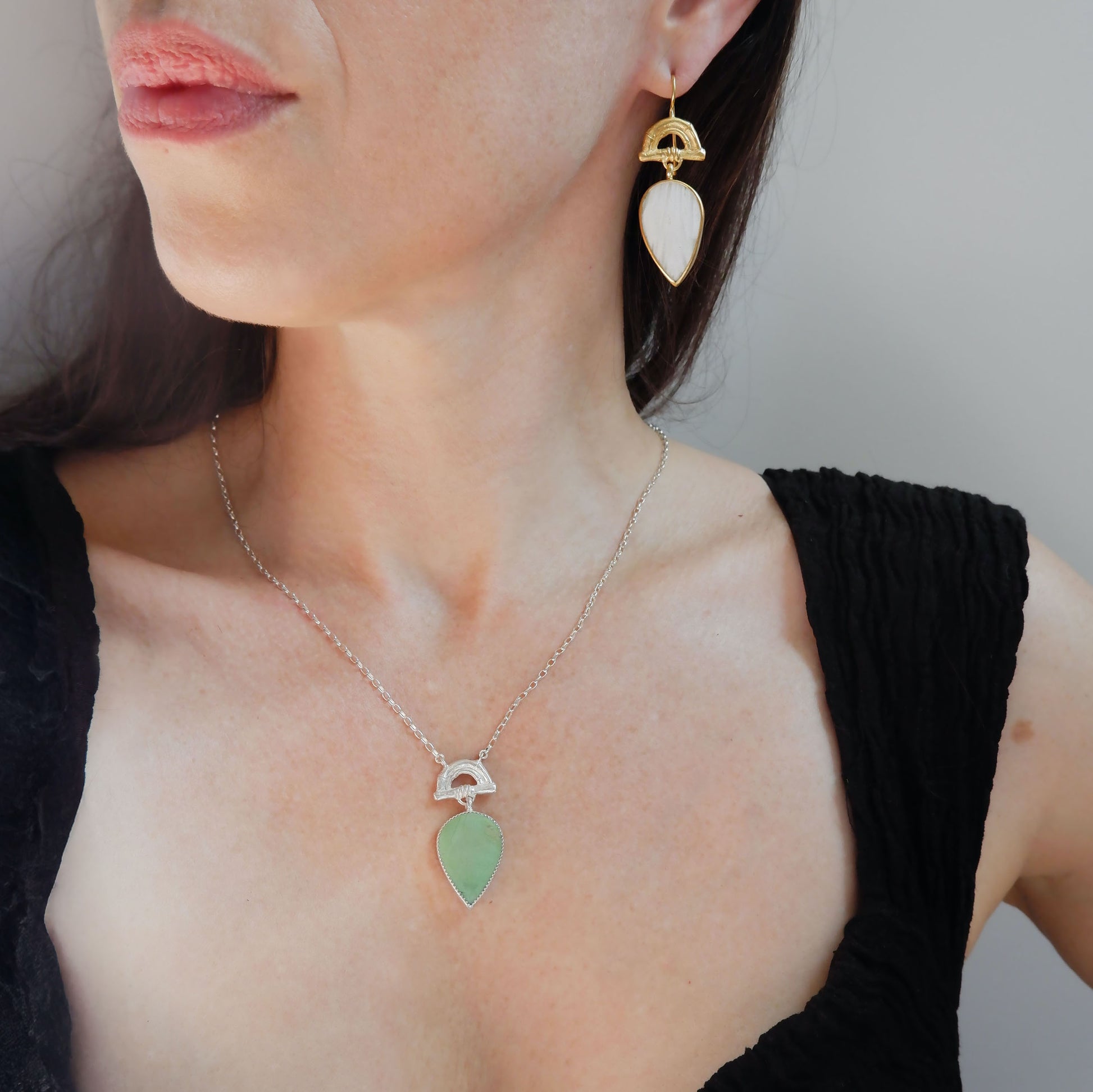 Pendant with long Pear-shaped Gree Turquoise Gemstone hanging from silver Bamboo Arch, on fine silver chain. Shown on model, with matching earring with Gold bamboo arch & white scolecite pear shaped gemstone.