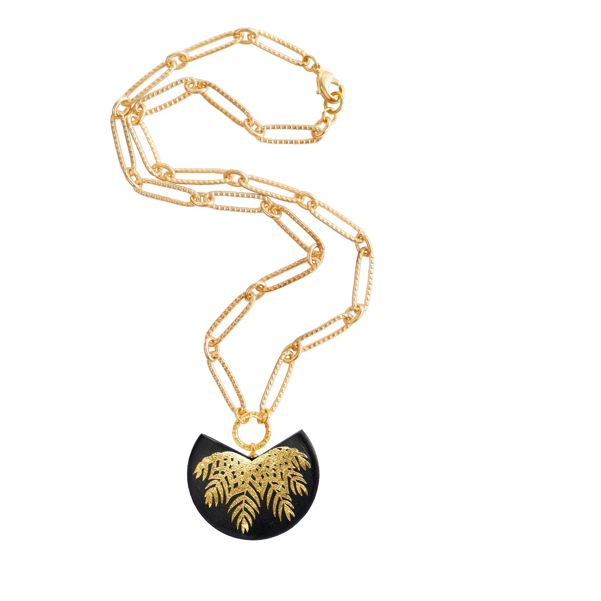 leather medallion pendant with gold palm tree print, on gold chain.