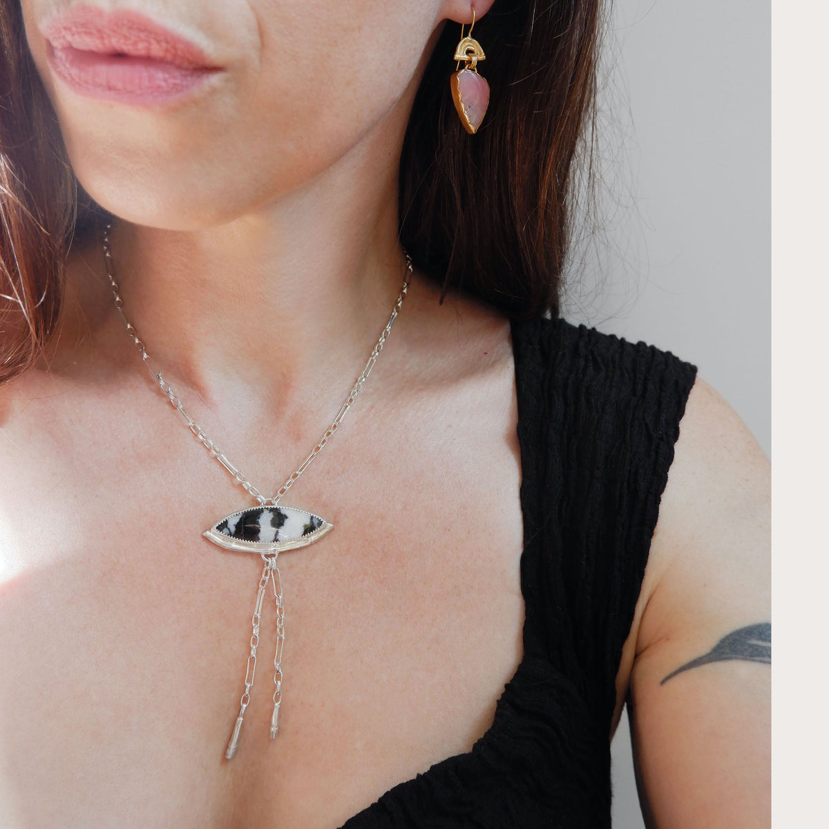 Silver Lariat style chain necklace, with a marquise cut black & white stripe Zebra Jasper gemstone pendant, framed  by a half halo of silver bamboo.  Shown on model