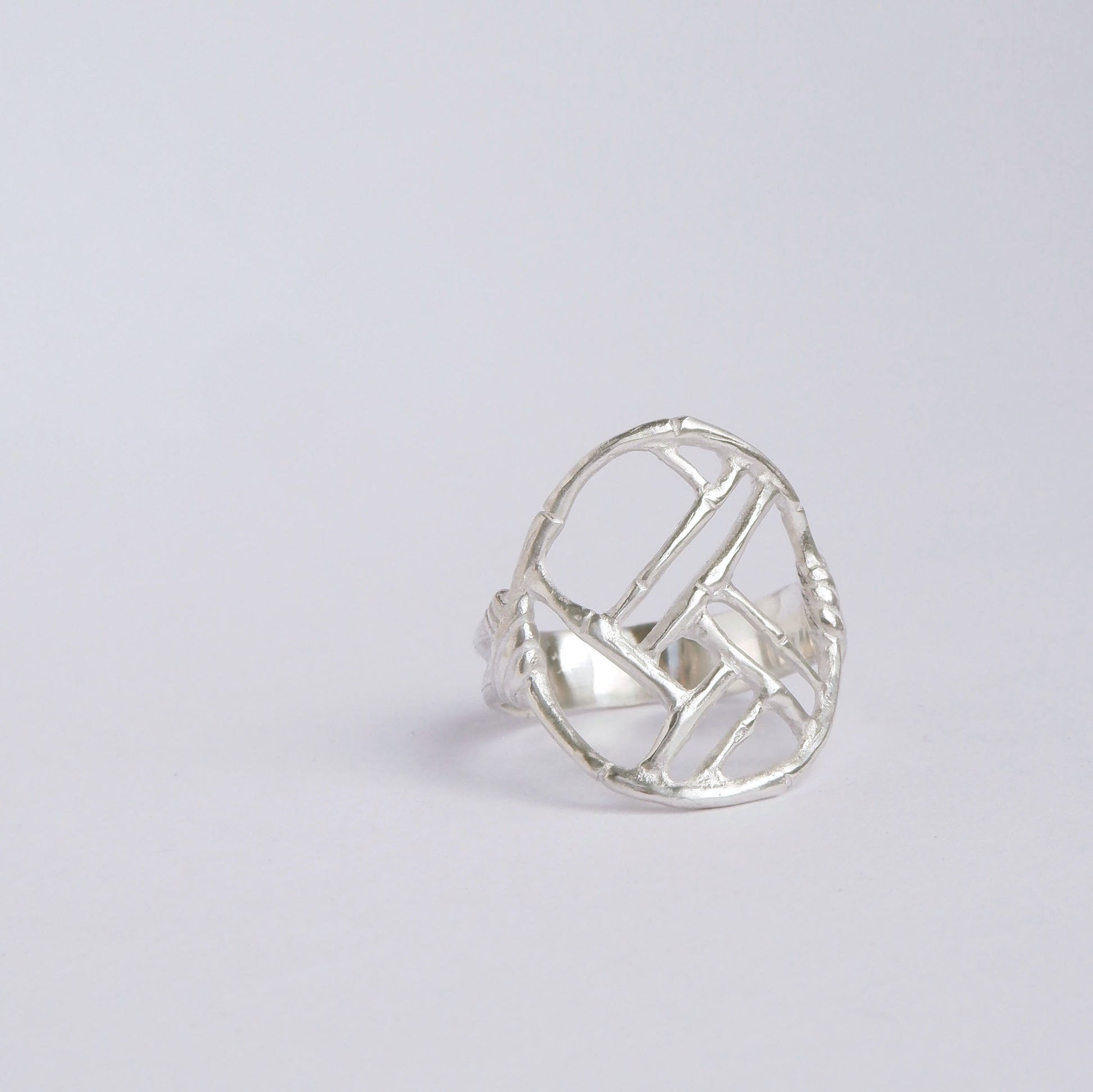 Sterling Silver ring with geometric open-work Bamboo Circle screen design, on a white background