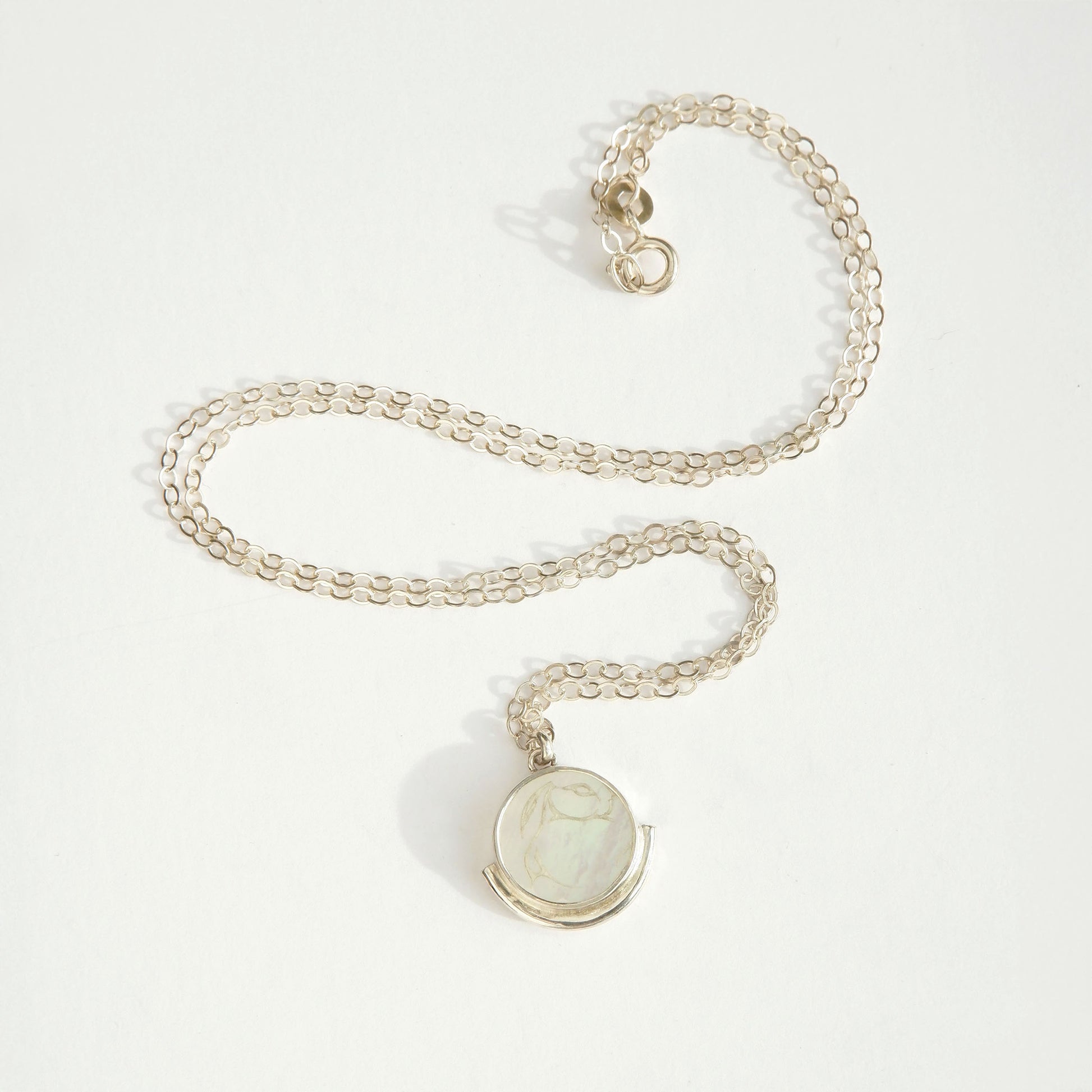 engraved mother of pearl medallion pendant, with white rabbit design, on fine sterling silver trace chain