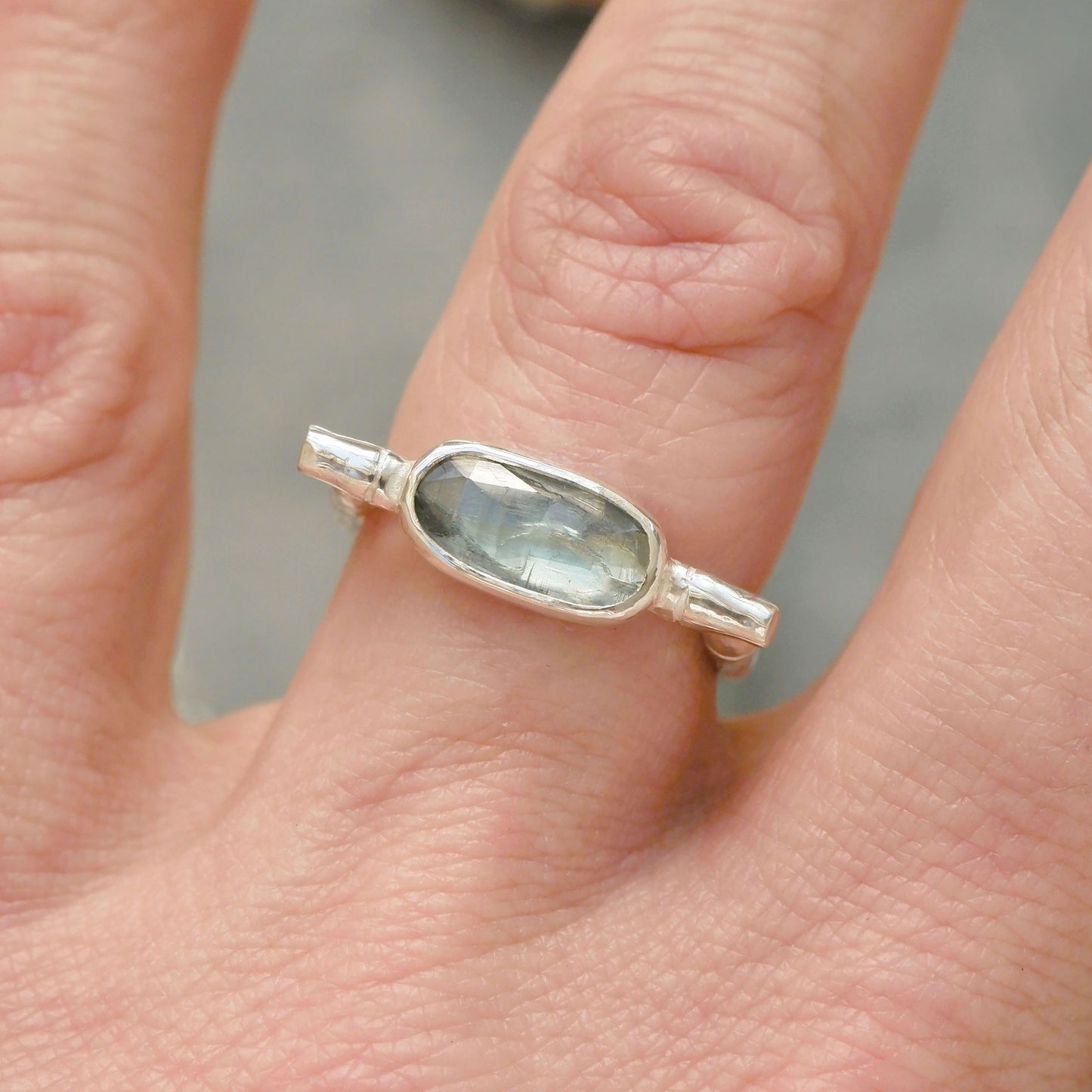 sterling silver organic bamboo cane ring, set with pale mint green kyanite cabochon, on finger