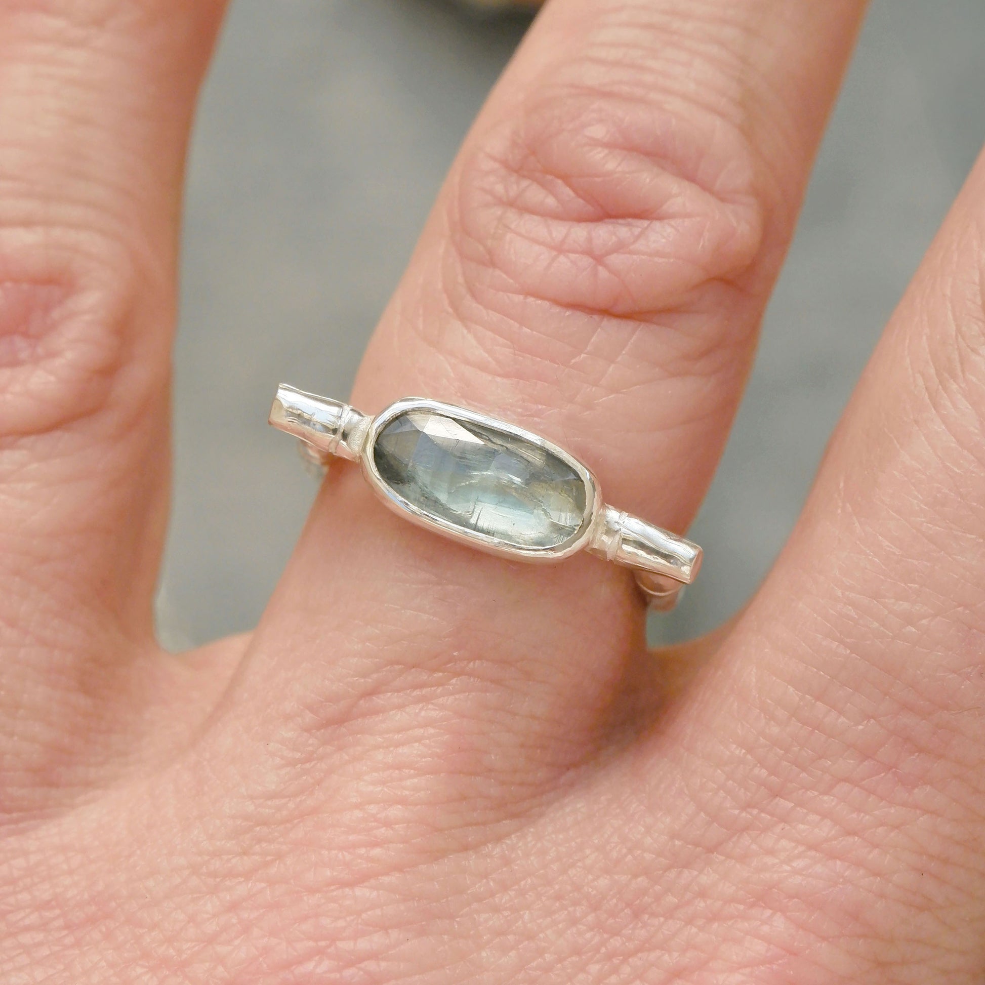 sterling silver organic bamboo cane ring, set with pale mint green kyanite cabochon, on finger