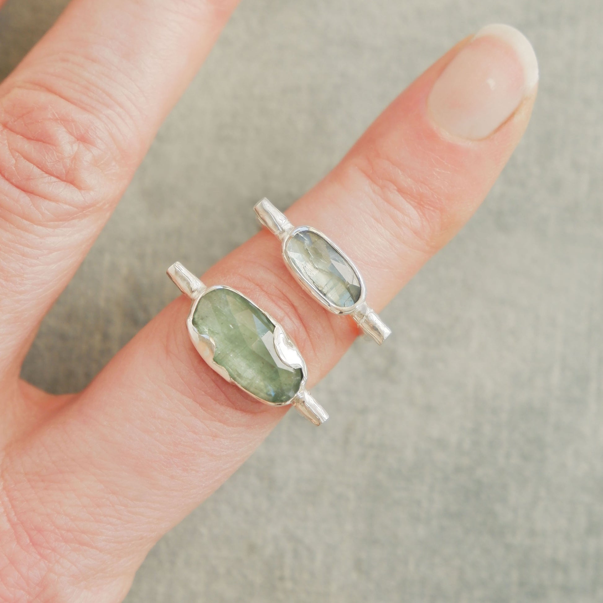 2 different sizes of sterling silver organic bamboo cane ring, set with pale mint green kyanite cabochon on finger