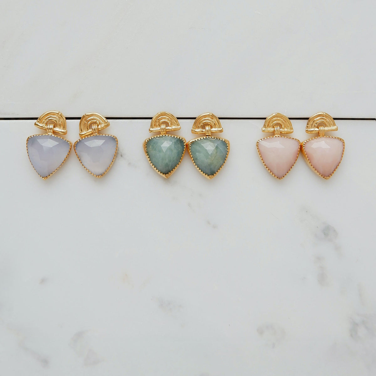 three pairs of Gold Vermeil stud drop earrings , featuring triple arches of bamboo, paired with hanging faceted Trillion shaped gemstone charm pendant, set with serrated gold teeth. 
Lavender Chalcedony, aquamarine & Pink Opal