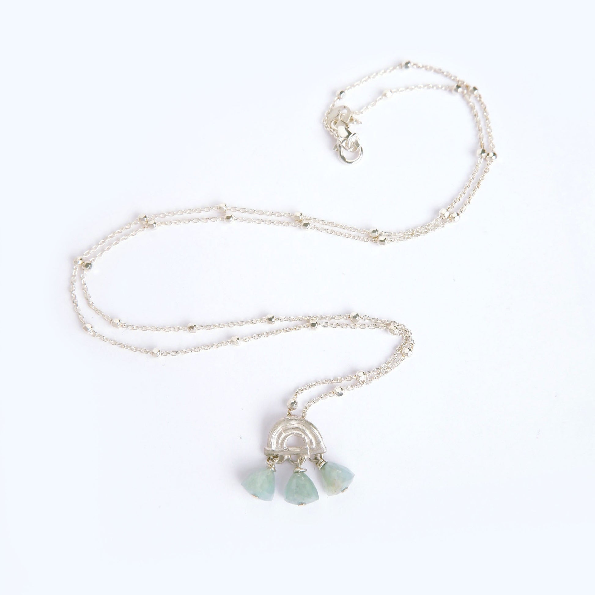small pendant in sterling silver, featuring a triple arch of bamboo, fringed with pyramid trillion beads in aquamarine, on beaded satellite chain in sterling silver.