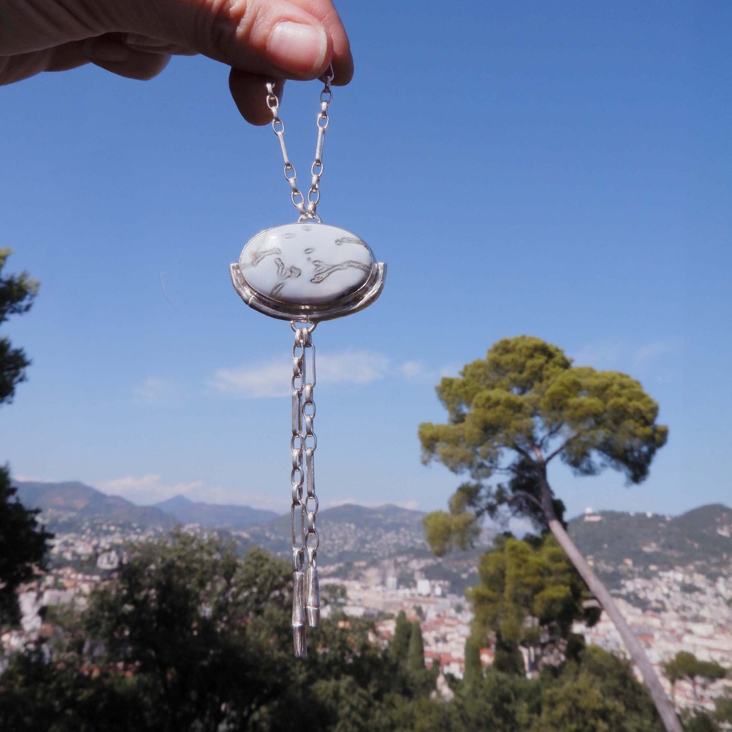 Silver Lariat style chain necklace, with a large marbled pale sky blue peruvian opal pendant, framed  by a half halo of silver bamboo
