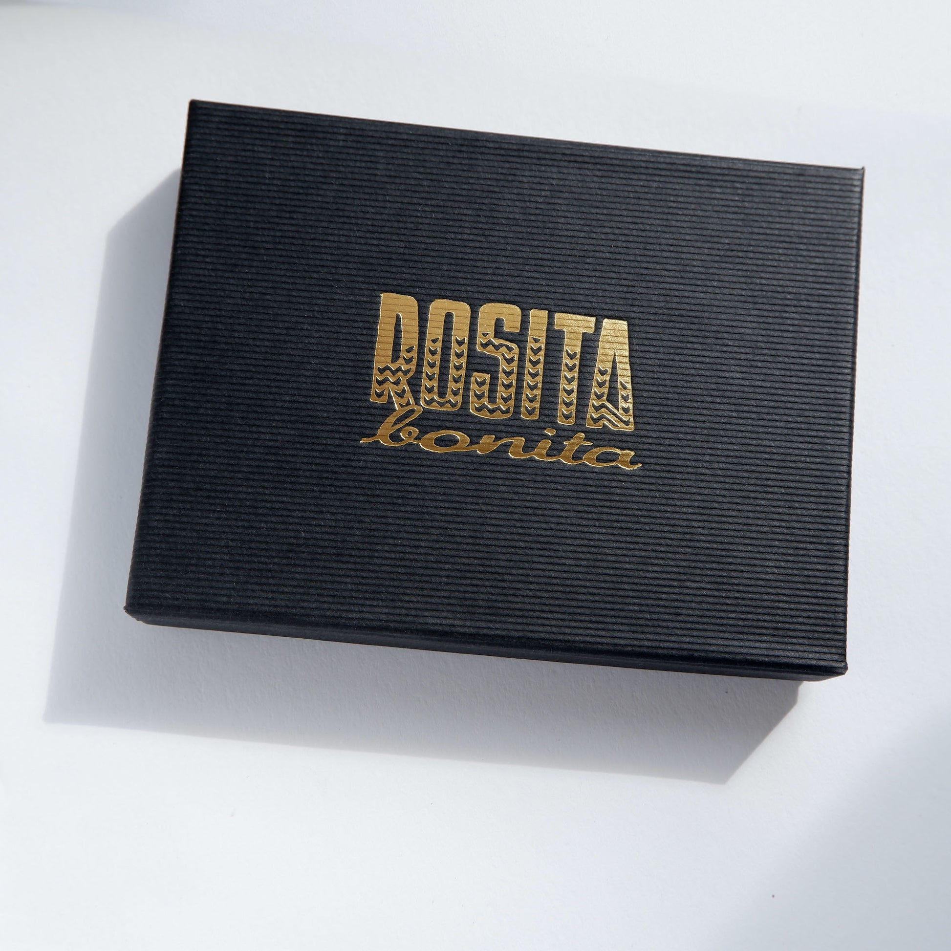 black ribbed cardboard box with Rosita Bonita logo in gold